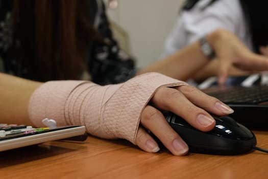 Asian women hand sore working on her computer