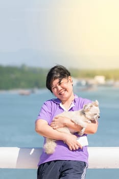 Asia woman plump body and her dog standing at estuary (river side and sea) when travel , process in soft orange sun light style