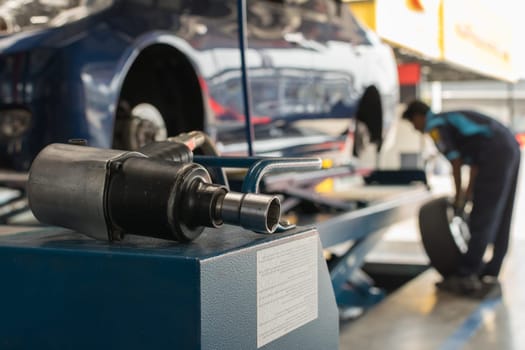 Serviceman checking suspension in a car at garage