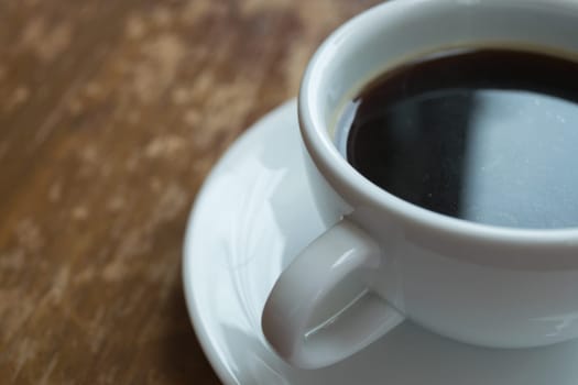 Coffee in white cup on wood table