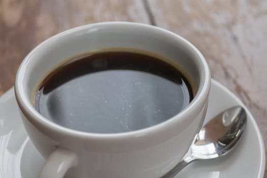 Coffee in white cup on wood table