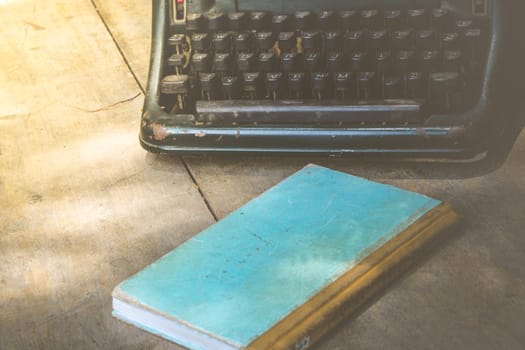 Vintage typewriter and a notebook on a wood table , process in vintage style