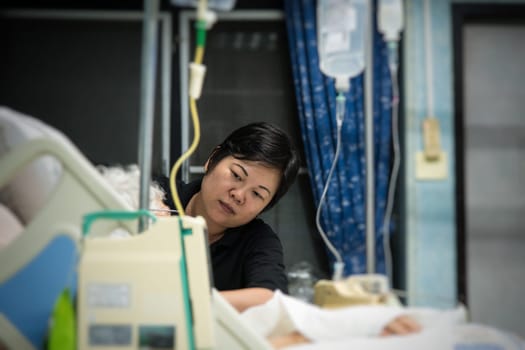 Asian women 40s years old is a patient relative taking care of the CRE. or VRE. infected elder patient 80s years old on bed in the hospital.