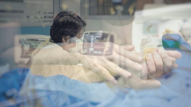 Asian women 40s years old in gown coat is a patient relative taking care of the CRE. or VRE. infected elder patient 80s years old on bed in the hospital.