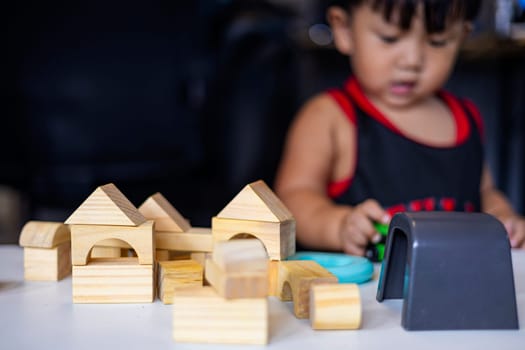 Little child play blocks in playroom. Learning by playing.