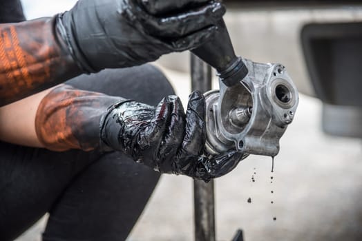 Car mechanic or serviceman disassembled car dirty engine for cleaning fuel injection and air flow system engine parts for fix and repair problem at car garage or repair shop