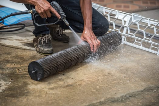 Worker to cleaning coil cooler of air conditioner by water for clean a dust on the wall in customer home when maintenance service