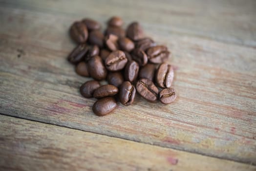 Coffee beans and roasted coffee beans on wooden table in a cafe or coffee shop, traditional vintage style concept