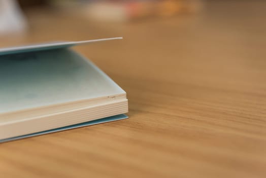Notebook or note paper sheet in retro style with brown cover and blank white paper on wooden table or desk in business and education concept