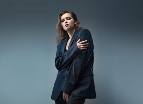 A stylish studio photoshoot featuring a model wearing a chic blazer over a trendy top, set against a neutral background. Perfect for highlighting modern fashion and elegant styling