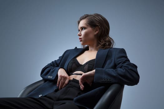 A stylish studio photoshoot featuring a model wearing a chic blazer over a trendy top, set against a neutral background. Perfect for highlighting modern fashion and elegant styling