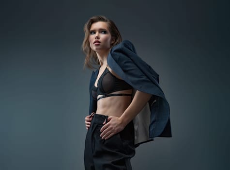 A stylish studio photoshoot featuring a model wearing a chic blazer over a trendy top, set against a neutral background. Perfect for highlighting modern fashion and elegant styling