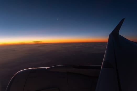View of the red horizon line and the wing of the aircraft. Passenger POV from the plane