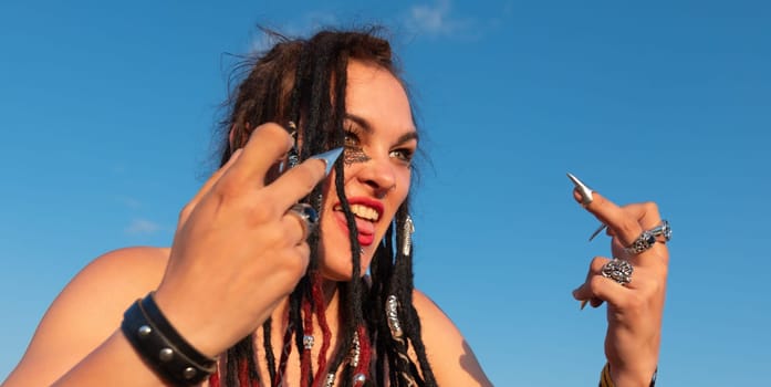 A portrait of an emotional beautiful nude young punk woman with piercing, dreads and stylish make-up. Emotionally gesturing and posing