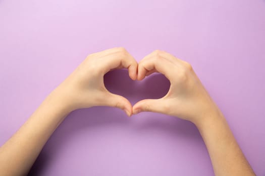 A touching image of hands gracefully forming a heart shape against a vibrant purple background, symbolizing love, care, and connection, perfect for creative and emotional designs