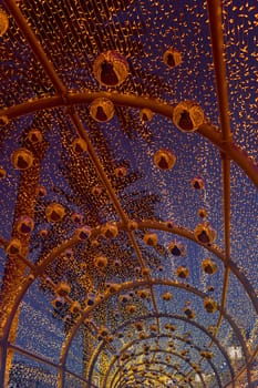 an alley decorated with New Year's garlands and golden balls in center of Dubai at dusk, Christmas decorations with palm trees on the background. High quality photo