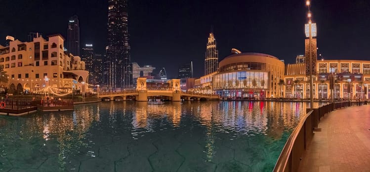 UAE, Dubai, 10 December 2024: The famous shopping center Dubai Mall and Burj Khalifa skyscraper at dusk, Dubai's sights and skyscrapers illuminated at night, palm trees. High quality photo