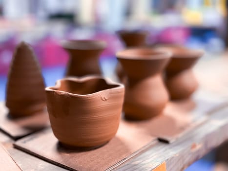 Handmade clay vessels on display in pottery workshop.