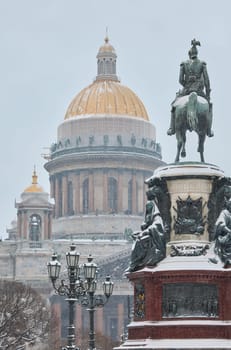a snow-covered New Year's city decorated for the celebration of the new year, the golden dome of St. Isaac's Cathedral, walking tourists. High quality photo