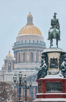 a snow-covered New Year's city decorated for the celebration of the new year, the golden dome of St. Isaac's Cathedral, walking tourists. High quality photo