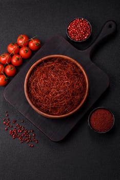 Red thin hot chili threads on a dark background. For decorating Asian dishes