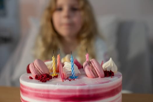 A beautiful birthday cake decorated with vibrant macarons and colorful candles, perfect for celebrations