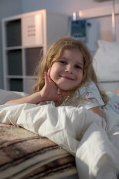 A joyful young girl is relaxing peacefully on her cozy bed, showcasing her innocence and a sense of comfort