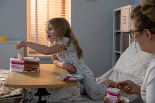 In a cozy hospital environment, a child joyfully shares a delicious cake with a loving caregiver, creating warmth