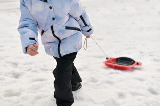 A boy with bob sledding in the snow