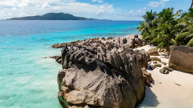 Natural rock formations and crystal clear water on a tranquil sandy beach. La Digue, Seychelles.