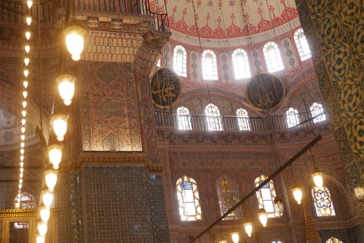 Visitors admire the ornate details of the mosque's interior at dusk.