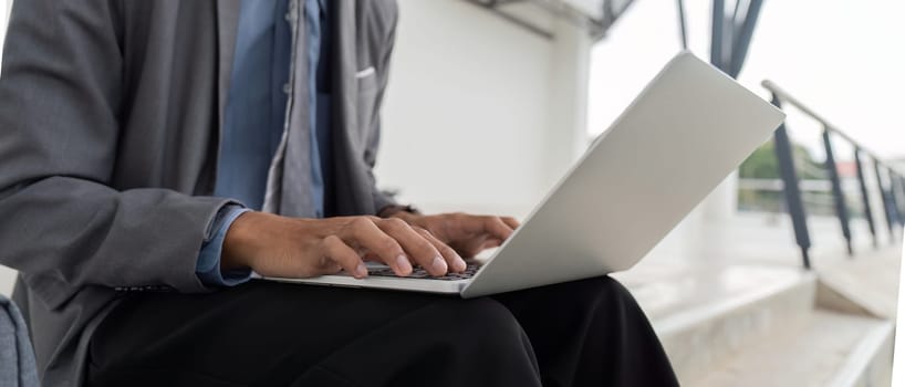 A business professional working on a laptop in a modern office environment, showcasing productivity and focus.