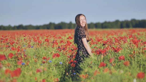 Young woman stands smiling amidst a vibrant field of red poppies, enjoying the beauty of a summer day