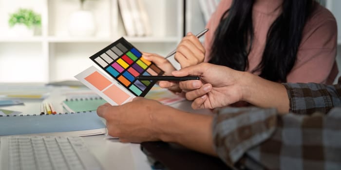 A diverse team evaluating multiple color palettes for a graphic design project in a modern office environment.