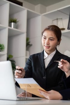 A lawyer providing clear explanations of legal documents to a client, using a laptop for reference in a professional office setting.