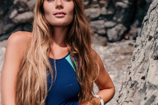 Woman travel sea. Young Happy woman in a long red dress posing on a beach near the sea on background of volcanic rocks, like in Iceland, sharing travel adventure journey