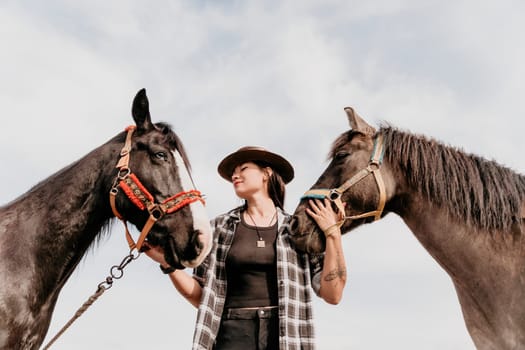 Cute happy young woman with horse. Rider female drives her horse in nature on evening sunset light background. Concept of outdoor riding, sports and recreation.