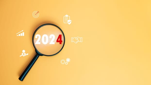 Magnifying glass focused on letter 2024 on yellow background. Represents setting goals for 2024, Startup concept. Financial planning, development, Business strategy, Setting business goals.