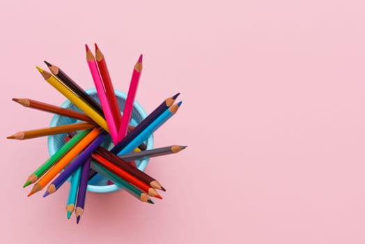 Colored wooden pencils on pink background, education concept