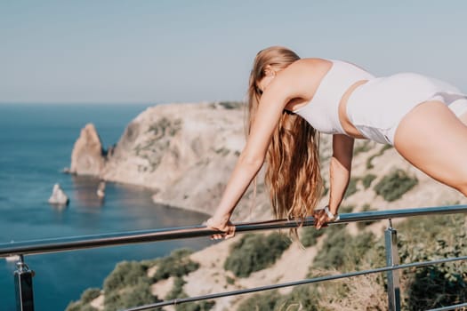 Fitness woman sea. Outdoor workout on yoga mat in park near to ocean beach. Female fitness pilates yoga routine concept. Healthy lifestyle. Happy fit woman exercising with rubber band in park.