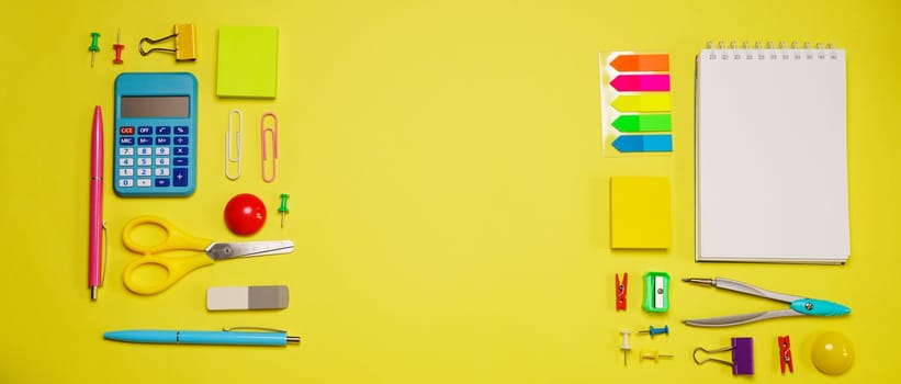 Notebook on a spring for notes and stationery lie on a yellow background, the concept of back to school, colorful school supplies