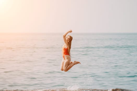 Woman sea yoga. Back view of free calm happy satisfied woman with long hair standing on top rock with yoga position against of sky by the sea. Healthy lifestyle outdoors in nature, fitness concept.