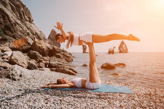 Woman sea yoga. Back view of free calm happy satisfied woman with long hair standing on top rock with yoga position against of sky by the sea. Healthy lifestyle outdoors in nature, fitness concept.