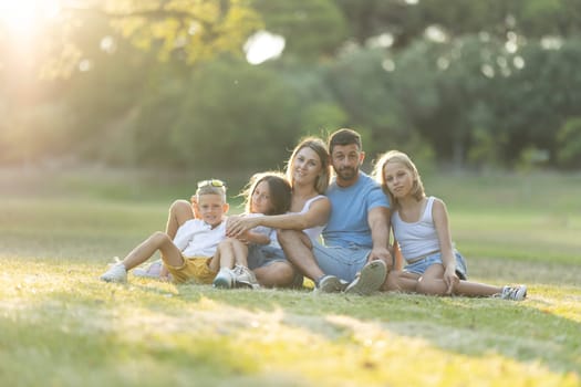 Family enjoying a sunny day outdoors, sitting on grass