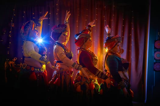 Four women in colorful traditional costumes pose for photo. A tribal dancer poses for a photo shoot