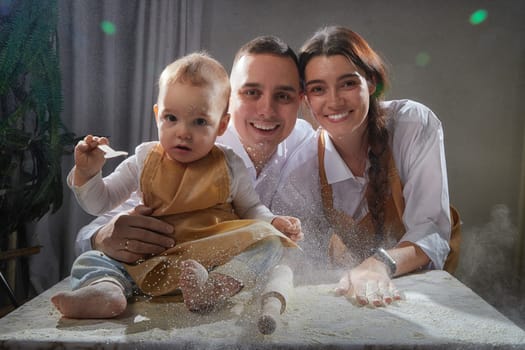 A family enjoys a fun cooking session, playfully covered in flour while engaging with their little ones in warm kitchen