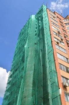 brick house under construction with wooden scaffolding