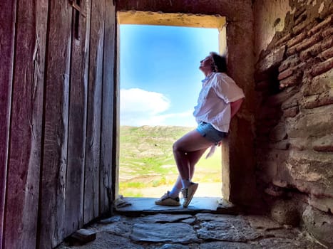 A mature woman enjoys a peaceful moment exploring beautiful landscapes, reflecting on her travels.