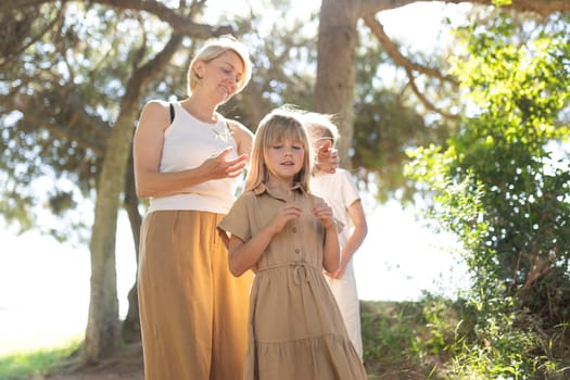 Family bonding outdoors under trees in bright sunlight