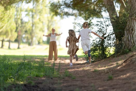 Kids joyfully running to parent through a sunlit forest path